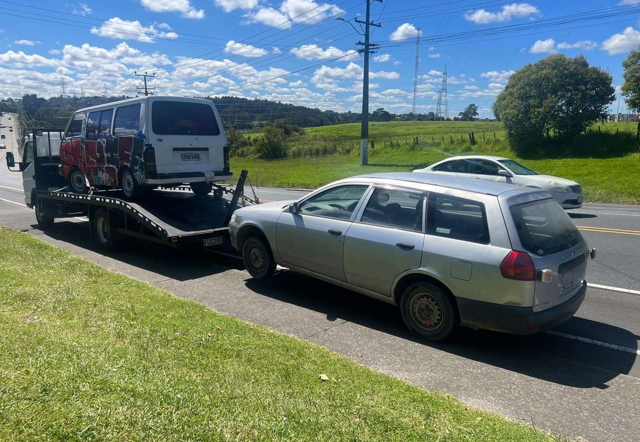 Cash For Cars Queenstown tow truck loaded with a van and towing a wagon on the Southern Lakes roadside